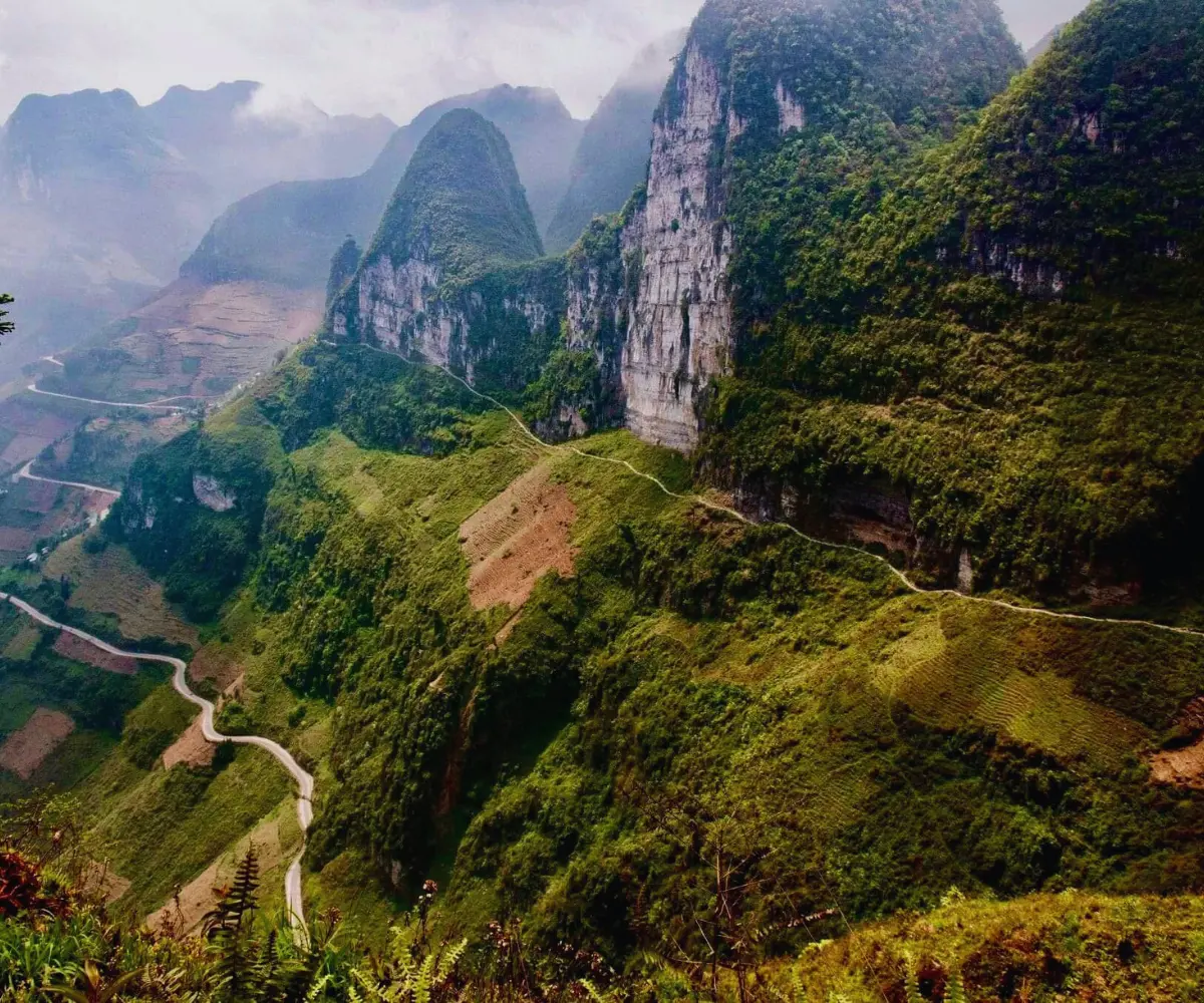 The Dong Van Karst Plateau features layers of rugged "cat ear" limestone mountains and hidden villages nestled amidst the majestic natural landscape.